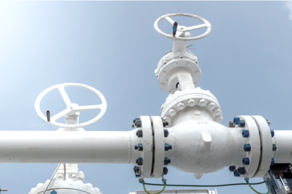 Weiße Rohrfernleitung mit Ventilen.