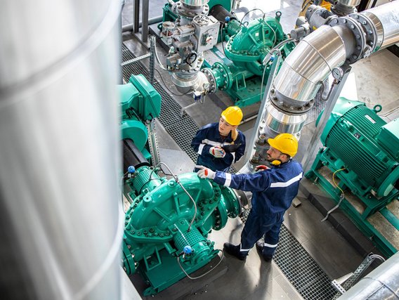 Inspektion einer Industriemaschine Zwei Ingenieure inspizieren eine Maschine.