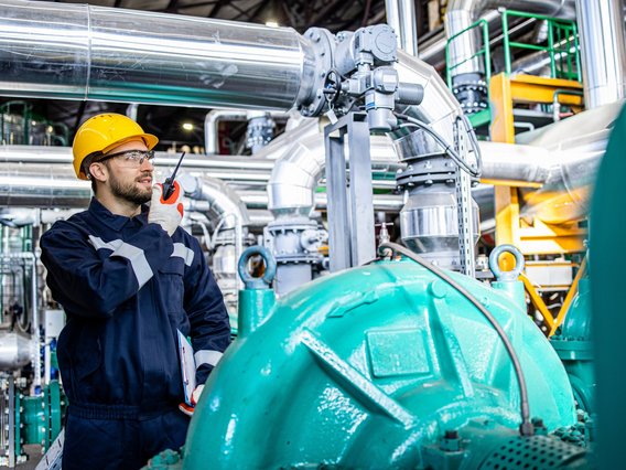 Ingenieur in einer Anlage kommuniziert über Funkgerät.